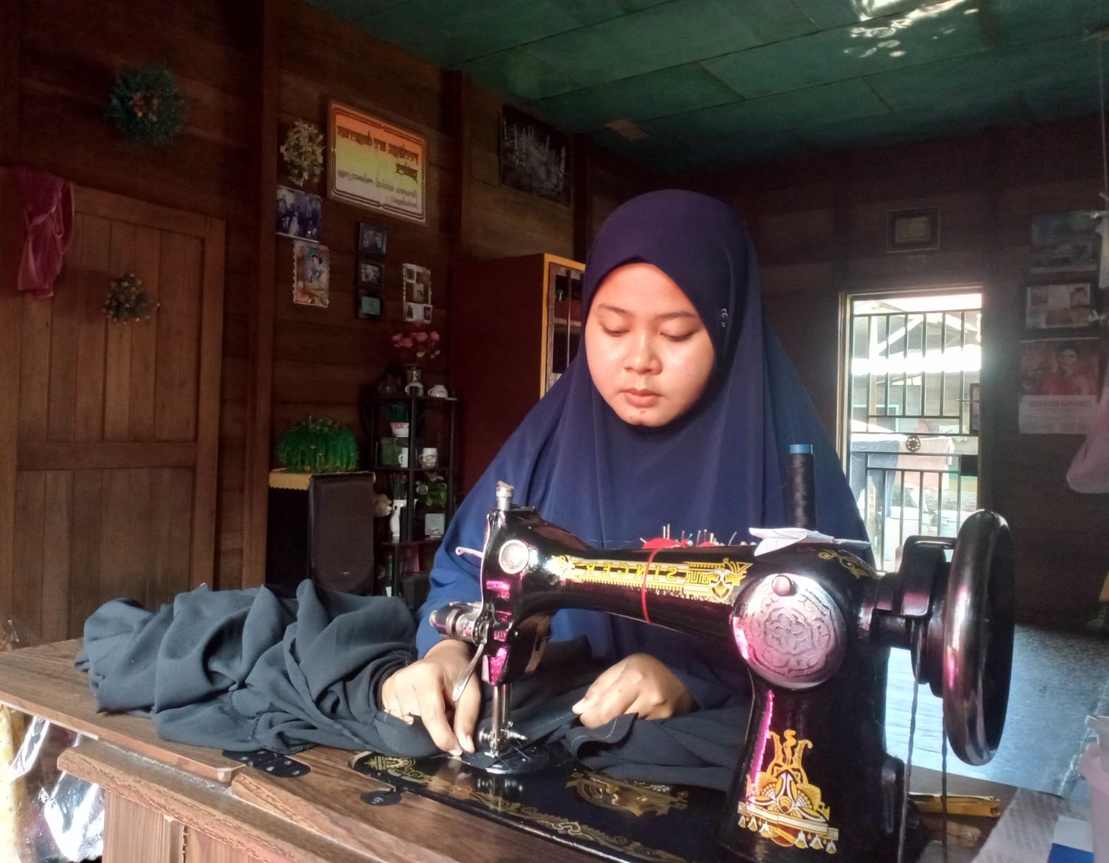 Laudia Cinta Bella saat menjahit baju pesanan konsumen. Laudia membuka usaha menjahit di rumahnya, di Bagansiapiapi, Rokan Hilir, usai menjalani pelatihan menjahit pada Program Penguatan Vokasi PHR.