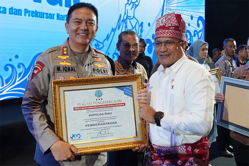 Kapolda Riau Irjen Pol Mohammad Iqbal menerima piagam penghargaan dari Kepala BNN RI Komjen Pol Marthinus Hukom pada acara puncak peringatan Hari Anti Narkotika Internasional di SKA Co-Ex, Pekanbaru.