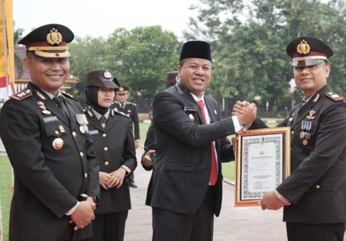 Bupati Kuansing, Dr Suhardiman Amby MM didampingi Kapolres Kuansing, AKBP Pangucap Priyo Soegito SIK MH menyerahkan piagam kepada Kapolsek Kuantan Mudik, AKP Hendra Setiawan