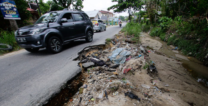 JALAN RUSAK: Pengendara melintas di Jalan Srikandi, Kecamatan Binawidya yang mengalami amblas di bagian pinggir jalan, sehingga tidak bisa langsung dilintasi dua kendaraan roda empat, Rabu (19/6/2024)