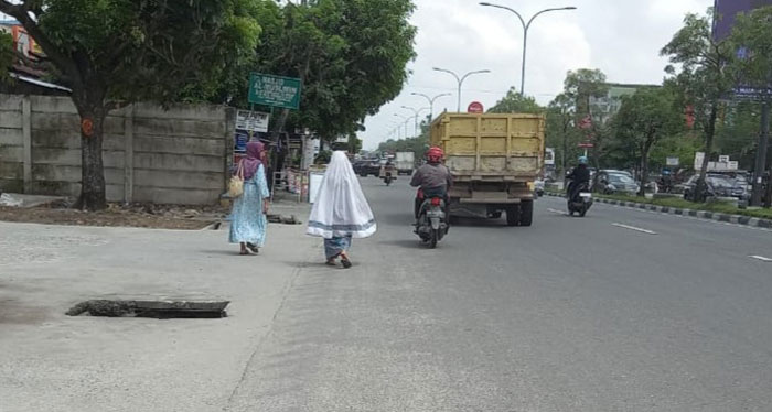 MENGANGA: Lubang drainase menganga di pinggir Jalan HR Soebrantas Km 13, Pekanbaru, Senin (1/7/2024).
