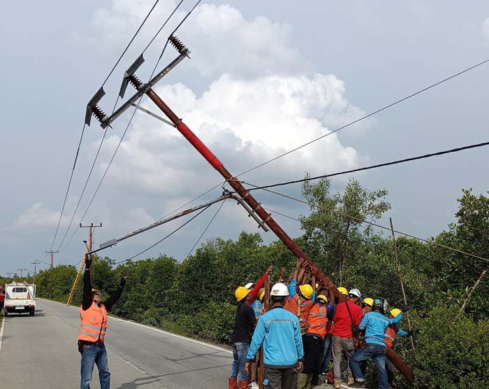 Petugas PLN Rayon Bengkalis berupaya menegakkan tiang yang tumbang di Jalan Lintas Bantan, tak jauh dari Jembatan Sungai Liong, Kecamatan Bantan.