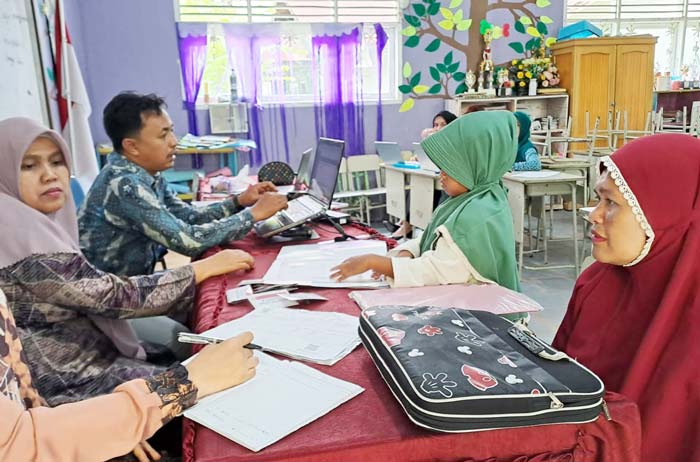Panitia PPDB SDN 25 Pekanbaru membantu orang tua calon murid untuk mendaftar secara online, Kamis (4/7/2024).