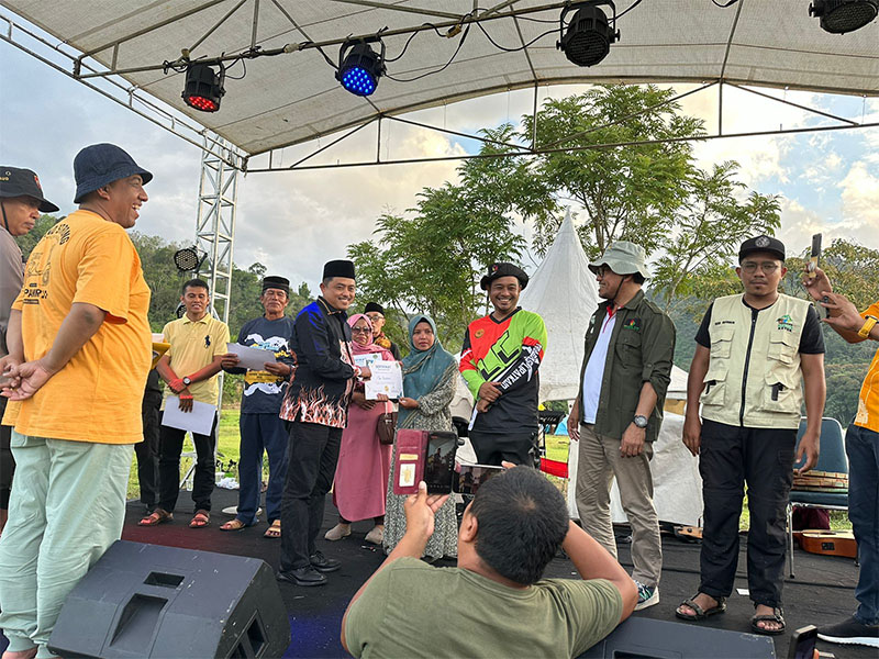 Wakil Ketua DPRD Kampar Repol memberikan sertifikat penghargaan kepada beberapa penerima yang andil dalam pengembangan wisata Subayang di Subayang Festival 2024, Sabtu (6/7/2024)