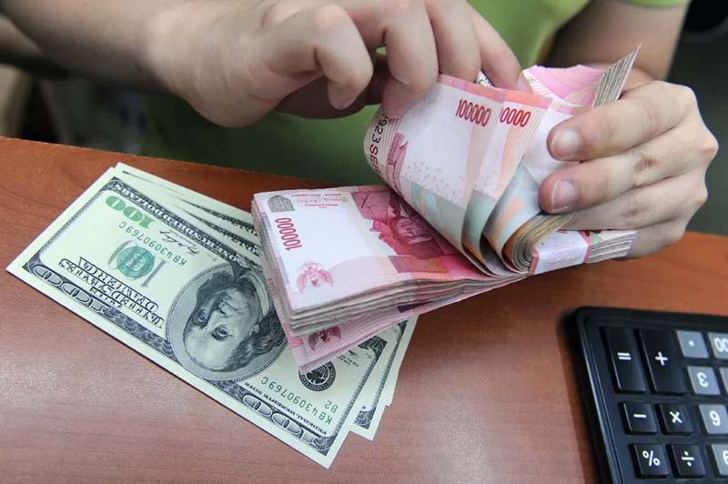 Pekerja sedang menghitung uang rupiah saat dilakukan penukaran dengan mata uang dolar AS di sebuah money changer, beberapa waktu lalu.