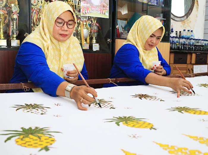 Dua pengrajin Batik Mandau tengah membuat batik dengan motif nanas di Workshop Batik Mandau, Jalan Jenderal Sudirman, Duri, Bengkalis, Jumat (5/7/2024).