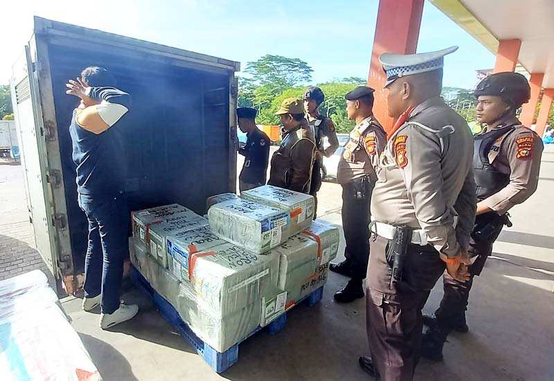 Personel Polres Rokan Hulu mengawasi penjemputan logistik Pemungutan Suara Ulang di salah satu kargo di Pekanbaru, Ahad (7/7/2024).