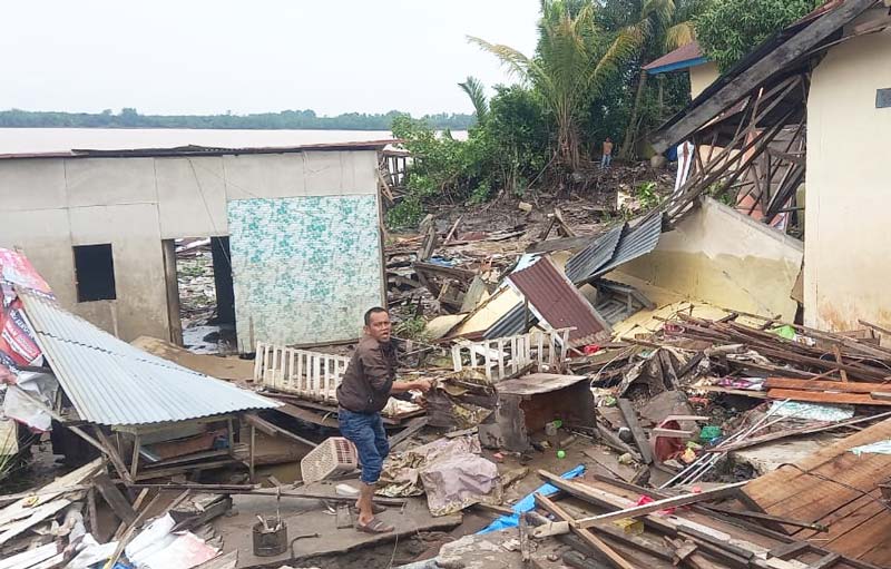 Salah seorang korban mencari barang berharga miliknya di antara reruntuhan bangunan akibat abrasi Sungai Indragiri di Tembilahan Hulu, Indragiri Hilir, Selasa (9/7/2024).