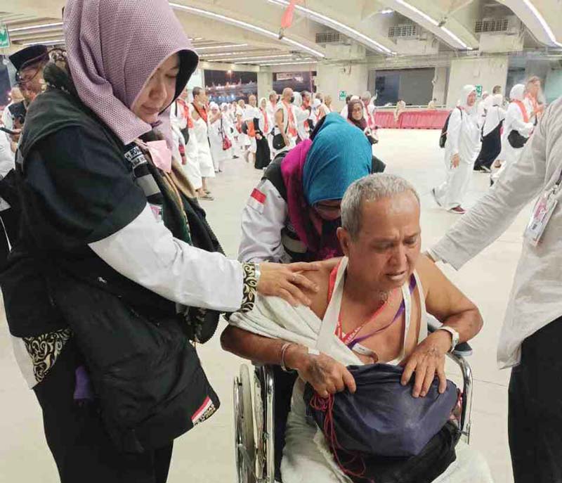 Dua personel PPIH Arab Saudi memijat seorang jemaah haji lanjut usia yang hendak melaksanakan lempar jumrah di area Jamarat, Mina, baru-baru ini.