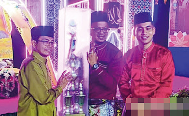 Kasi Kesosbud Kecamatan Pinggir Fahmi Ulul Albab (tengah) menyerahkan piala kepada kafilah RW 01 sebagai juara umum MTQ ke-5 tingkat Kelurahan Titian Antui di halaman Kantor Kelurahan Titian Antui