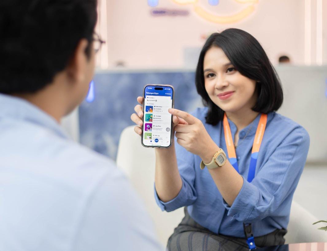 Pegawai Bank Raya menunjukkan aplikasi bank digital BRI Group ini kepada seorang nasabah, belum lama ini,