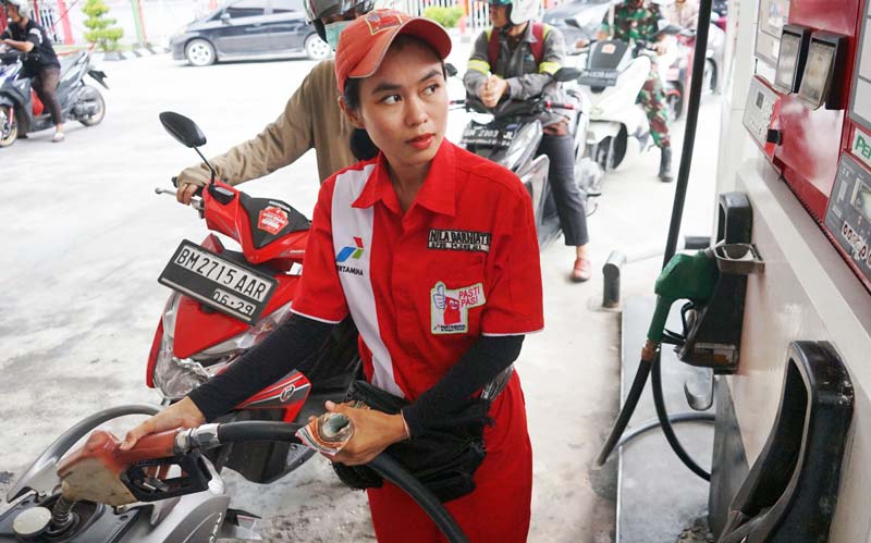 Seorang petugas mengisi BBM jenis pertalite ke tangki sepeda motor pengendara di Jalan Sudirman Pekanbaru, Jumat (12/7/2024).
