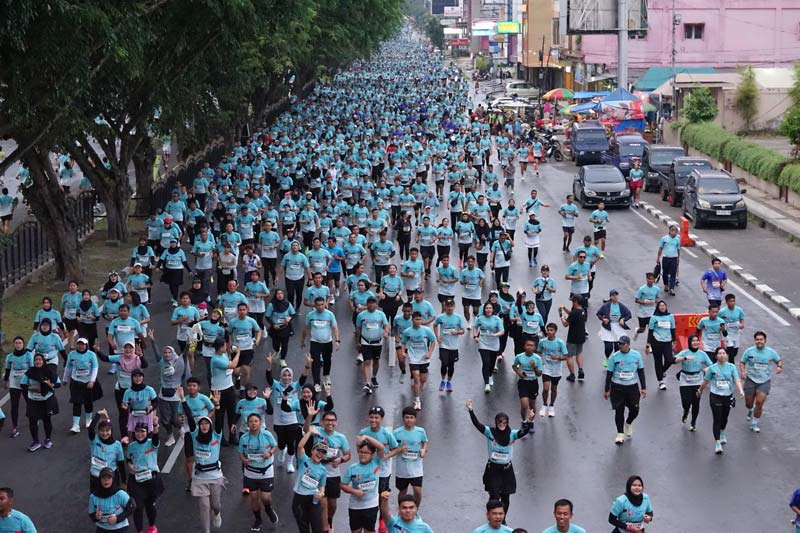 Ribuan peserta Riau Bhayangkara Run 2024 antusias saat melintasi Jalan Sudirman, Pekanbaru, Ahad (14/7/2024).