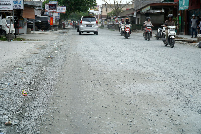 Pengendara melewati Jalan Cipta Karya, Kecamatan Tuah Madani yang sedang dalam tahap perbaikan, Ahad (14/7/2024).
