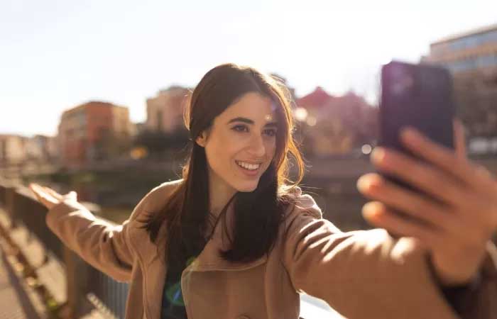 Ilustrasi seorang perempuan sedang selfie.