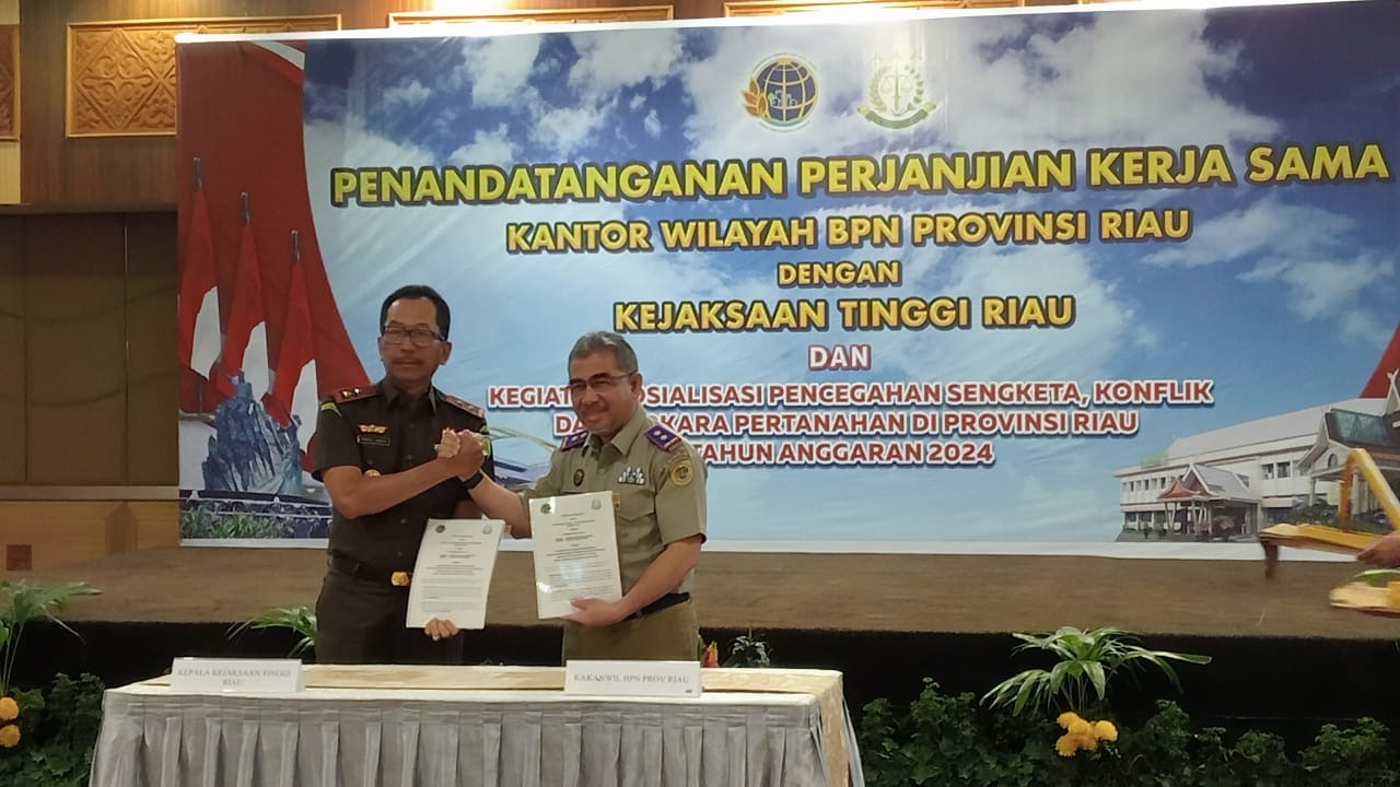 Kejati Riau Akmal Abbas SH MH (kiri) foto bersama Kepala Kanwil BPN Provinsi Riau Nurhadi Putra A. Ptnh MM usai melakukan penandatanganan kerjasama di hotel pangeran Pekanbaru, Selasa (16/7/2024).