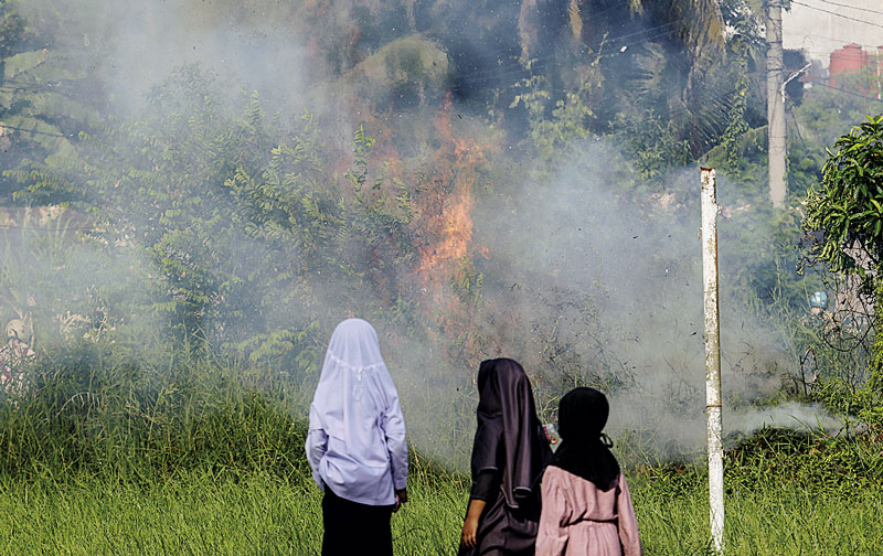 Sejumlah murid Madrasah Diniyah Takmiliyah Awaliyah  melihat secara langsung lahan kosong yang terbakar di Jalan Sri Gemilang, Kelurahan Perhentian Marpoyan, Kecamatan Marpoyan Damai, Pekanbaru, Rabu