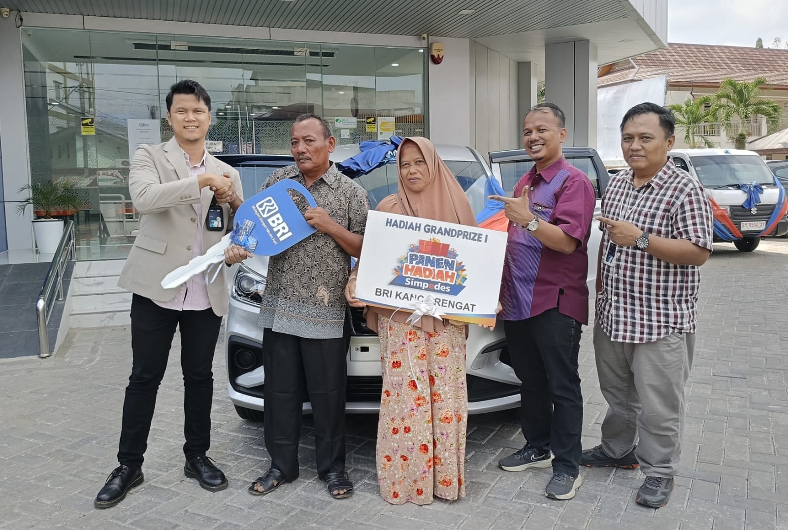Branch Manager BRI Rengat, Farianzi (kiri) didampingi dua pejabat BRI lainnya menyerahkan hadiah utama kepada Sruntul didampingi istrinya, Jumat (19/7/2024).