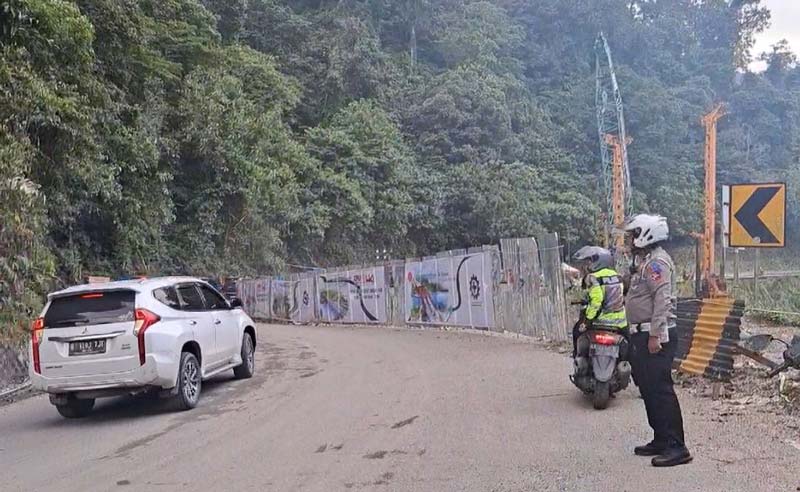 Petugas kepolisian mengatur lalu lintas di jalan kawasan Lembah Anai, Sumatera Barat saat dilakukan uji coba, Kamis (18/7/2024).