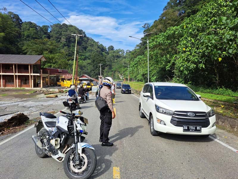 Personel Satlantas Polres Padang Pariaman memberlakukan sistem buka tutup di titik jalan yang masih dalam pengerjaan Jalur Padang-Bukittinggi.