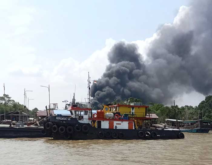 Asap hitam pekat api yang membakar PLTD Desa Lemang tampak dari Seberang Selat Air Hitam, Selasa (23/7/2024) siang.