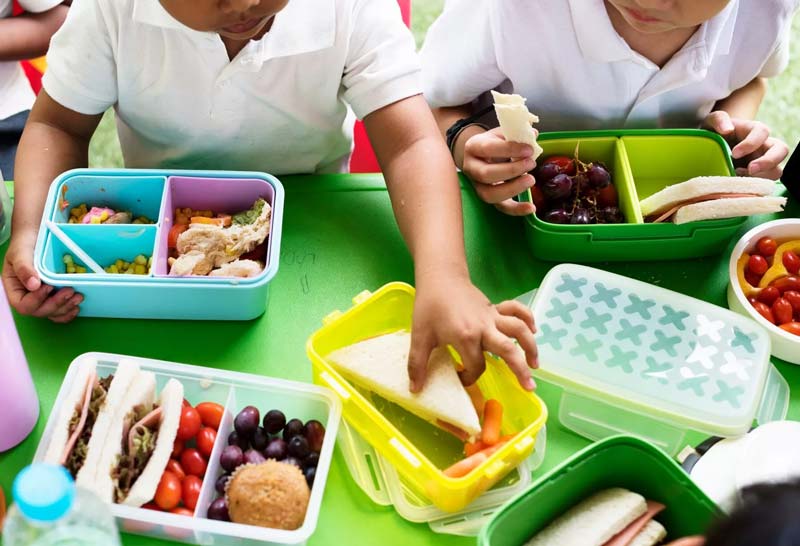 Ilustrasi anak-anak SD sedang makan siang.