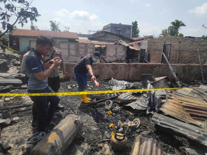 Personel Polres Inhu melakukan identifikasi dan lokasi kebakaran di tiga unit rumah warga sudah dipasang garis polisi, Ahad (28/7/024).
