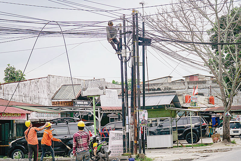 Sejumlah pekerja memasang&nbsp;kabel&nbsp;jaringan&nbsp;fiber optik di Jalan Cipta Karya, Kecamatan Tuah Madani, Senin (29/7/2024).  Keberadaan&nbsp;kabel&nbsp;jaringan&nbsp;yang bertumpuk dan semrawut