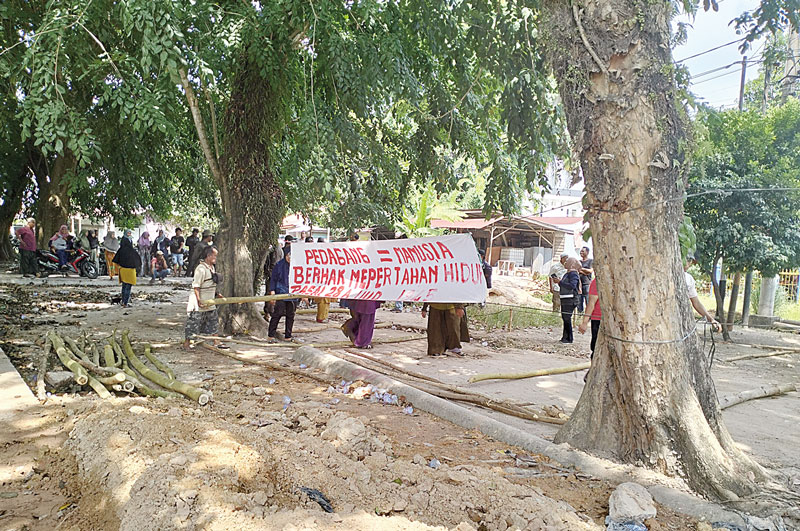Pedagang Pasar Kelakap Tujuh menggelar aksi damai di Jalan MH Thamrin, menuntut Wali Kota Dumai untuk segera menepati janjinya, Selasa (30/7/2024).