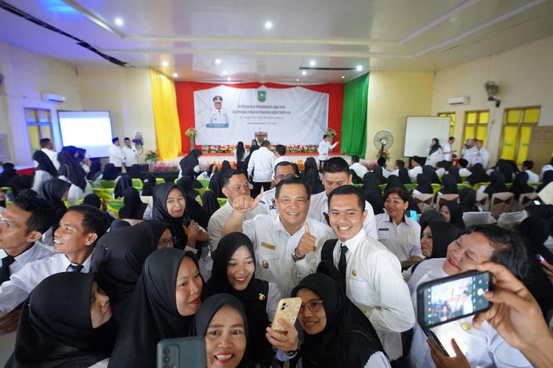 Penjabat Gubernur Riau SF Hariyanto foto bersama dengan penerima SK Pegawai Pemerintah dengan Perjanjian Kerja di SMA Negeri 1 Pasirpengaraian, Kabupaten Rokan Hulu, Rabu (31/7/2024).