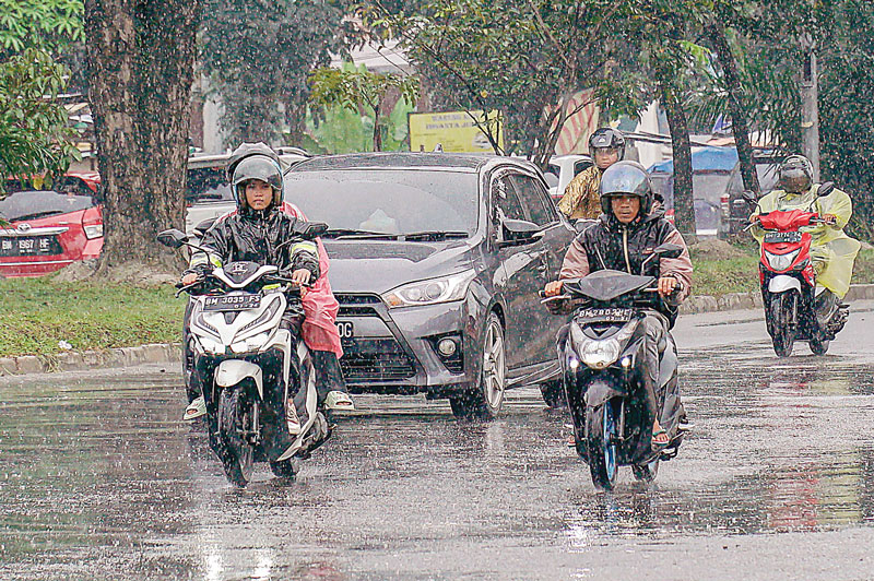 Pengendara sepeda motor&nbsp;menerobos&nbsp;guyuran&nbsp;hujan&nbsp;saat melintas di Jalan SM Amin, Kota Pekanbaru, Rabu (31/7/2024).