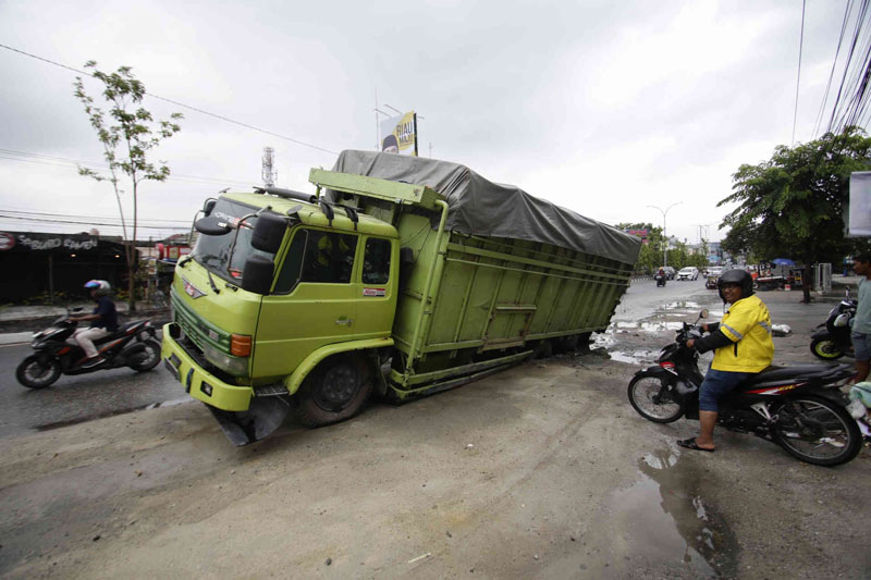 Satu unit truk bermuatan semen terperosok di bekas galian pipa air minum di Jalan Tuanku Tambusai, Pekanbaru, Rabu (31/7/2024).