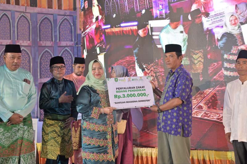 Bupati Bengkalis Kasmarni menyerahkan bantuan kepada pengurus masjid usai pembukaan MTQ ke-49 Tingkat Kecamatan Mandau di Masjid Agung Arafah, Duri, Kamis (1/8/2024) malam.