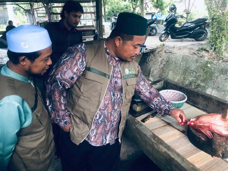Mustan Farijan dan Toto Prasetio dari Komisi Fatwa MUI Kabupaten Siak menjelaskan teknis memotong ayam yang benar kepada pemilik pemotongan ayam di Parit Baru.