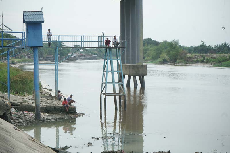 Sejumlah warga memancing di aliran Sungai Siak yang surut dampak musim kemarau di Pekanbaru, Senin (5/8/2024).