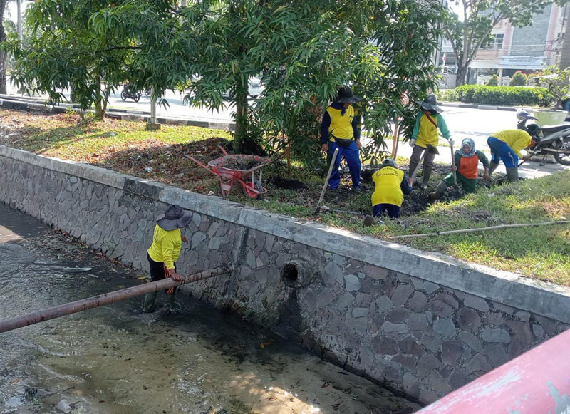 Pasukan kuning dari Dinas PUPR Pekanbaru melakukan pembersihan terhadap drainase di Jalan Jenderal Sudirman, Senin (5/8/2024).