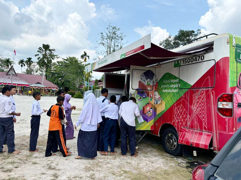 Para pelajar SMPN 1 Mempura antre di samping otobanking saat membuka buku tabungan BRK Syariah di halaman SMPN 1 Mempura, Senin (5/8/2024).