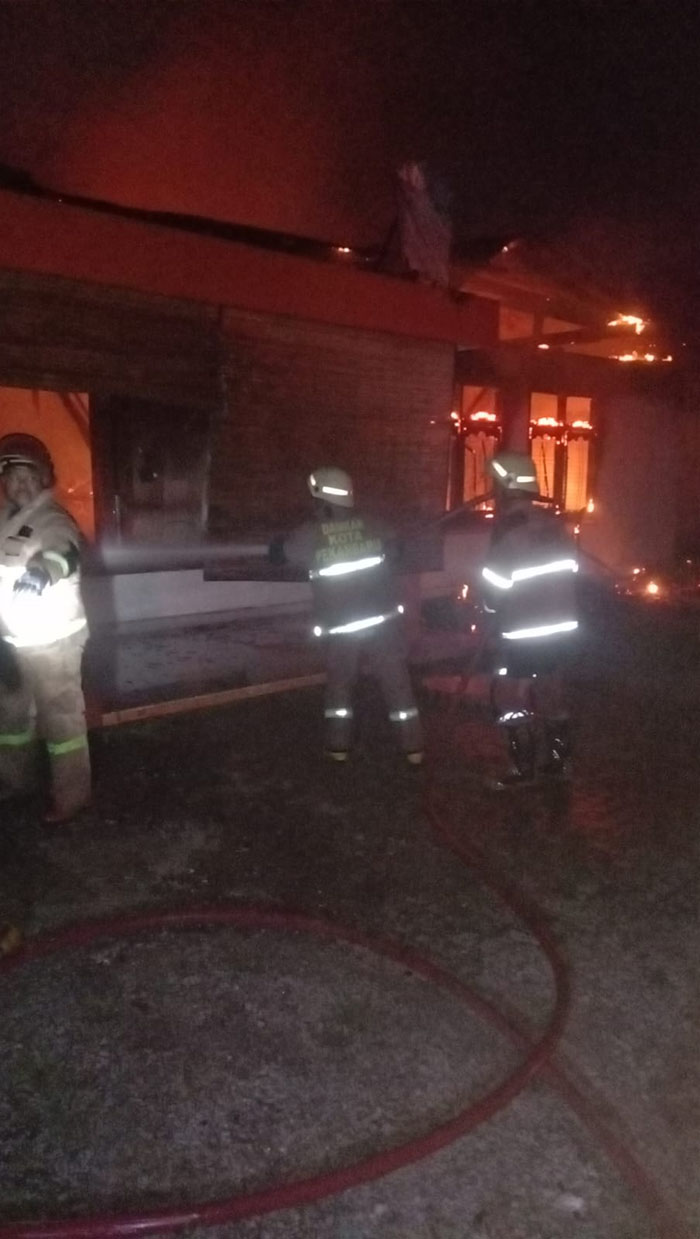Petugas berjibaku melakukan proses pemadaman tempat usaha Sinar Coffee di Jalan Ronggowarsito yang terbakar, Ahad (11/8/2024) malam.