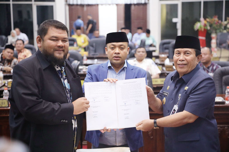 BERITA ACARA: Bupati Rohul H Sukiman bersama Ketua DPRD Rohul Novli Wanda Ade Putra didampingi Wakil Ketua DPRD Rohul Andrizal menunjukkan berita acara penandatanganan nota kesepakatan KUA dan PPAS ta