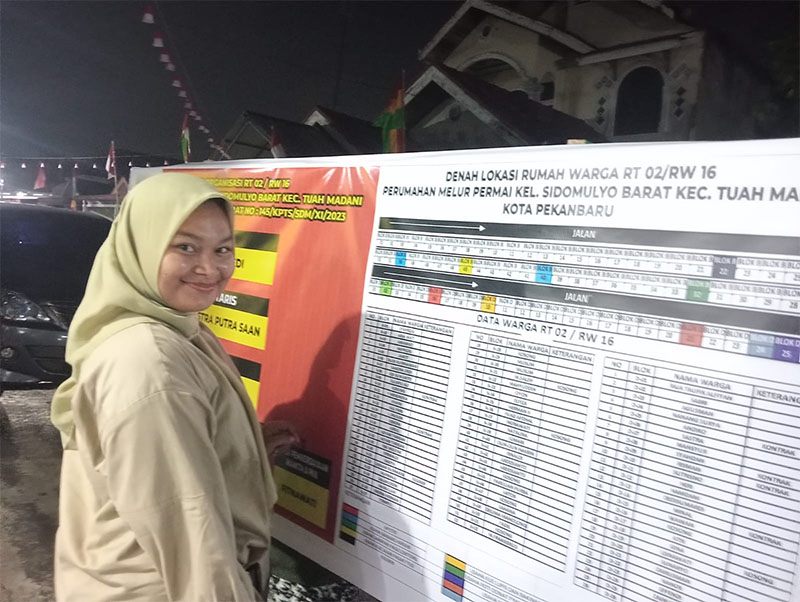 warga RT 2 Perumahan Melur Permai melihat nama-nama warga yang baru selesai dibuat untuk lomba HUT RI, Selasa (13/8/2024)