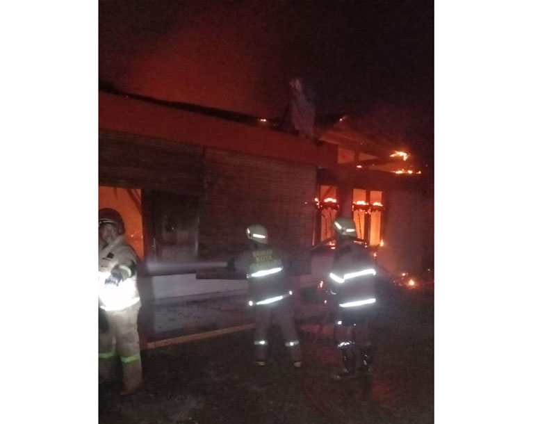 Petugas Dinas Pemadam Kebakaran dan Penyelamatan (DPKP) Kota Pekanbaru berusaha memadamkan api yang membakar bangunan Sinar Coffee di Jalan Ronggo Warsito.