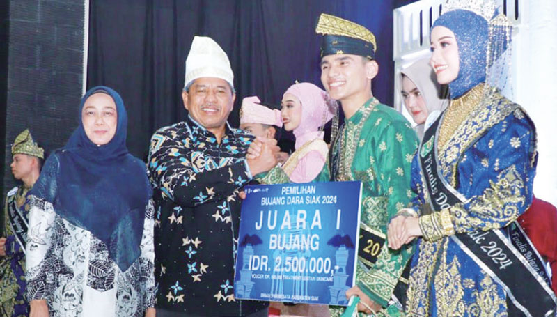 Bupati Siak Alfedri bersama istri Rasidah menyerahkan hadiah kepada Bujang Dara Siak 2024 M Farhan dan Vina Chantika di Siak, Jumat (9/8/2024).