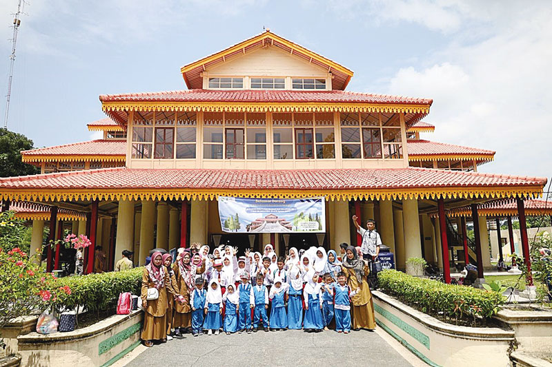 FOTO BERSAMA: Para pelajar foto bersama dengan latar Gedung Museum Budaya dan Sejarah Siak Balairung Sri, Siak Sri Indapura, Selasa (13/8/2024).