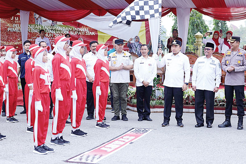 MELEPAS GERAK JALAN: Wabup Siak Husni Merza, Sekda Siak Arfan Usman dan Asisten I Setdakab Siak Fauzi Asni, melepas gerak jalan di depan Gedung Lembaga Adat Melayu Riau (LAMR) Kabupaten Siak,