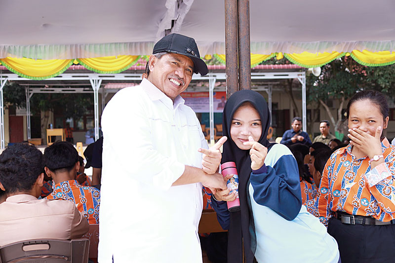 MENYERAHKAN TUMBLER: Bupati Siak Alfedri menyerahkan tumbler atau wadah air minum kepada siswi SMAN 1 dan SMAN 3 Kandis, Rabu (14/8/2024).