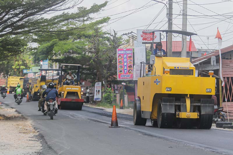 Dibantu alat berat, para pekerja melakukan perbaikan Jalan Cipta Karya, Kecamatan Tuah Madani yang sebelumnya rusak parah, Senin (12/8/2024).