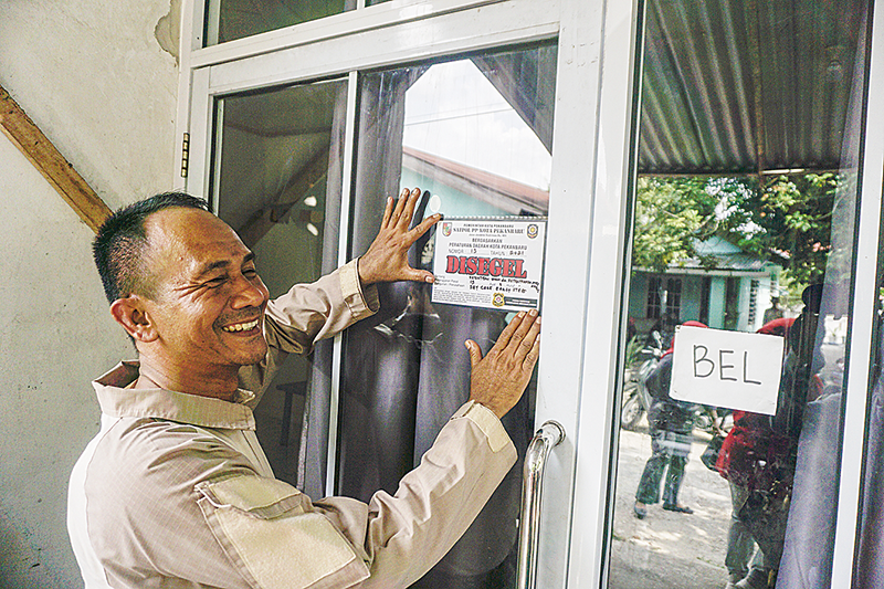 Petugas Satpol PP dan tim gabungan memasang stiker segel sebagai bukti penyegelan tempat penitipan anak Early Steps Daycare Pekanbaru di Jalan Kaharuddin Nasution, Kecamatan Bukit Raya.