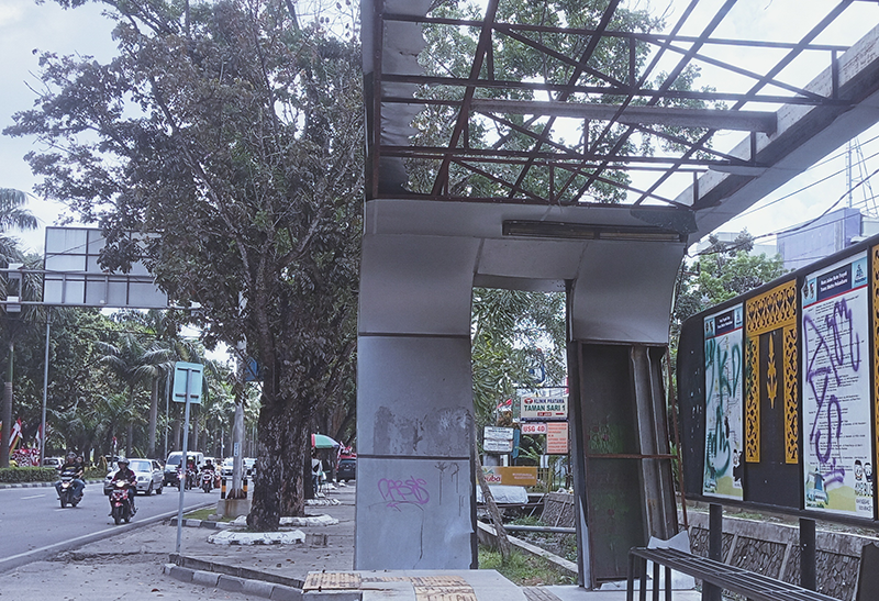Salah satu halte bus TMP depan Sudirman Square, Jalan Jenderal Sudirman penuh coretan dan rusak di bagian atap, Kamis (15/8/2024).