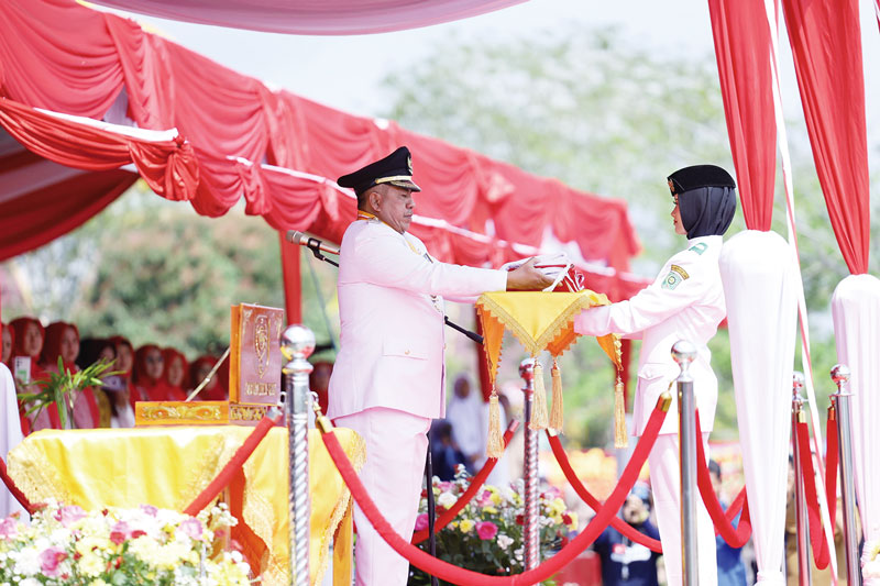 Bupati Siak Alfedri meletakkan bendera di atas baki yang dibawa Paskibra Vania Enzi, siswi SMAN 1 Siak, untuk dikibarkan dalam upacara detik-detik Proklamasi di halaman Kantor Bupati Siak,