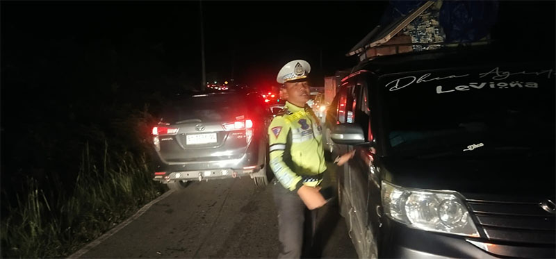 Personel Satlantas Polres Kampar mengatur lalu lintas di jalan lintas Riau-Sumbar Km 106-Km 107 yang amblas, Selasa (20/8/2024).